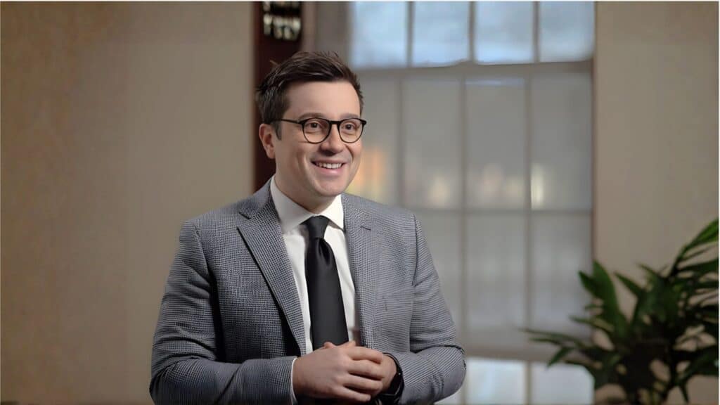 Smiling man in a suit using PrecisionOS dental simulation software.